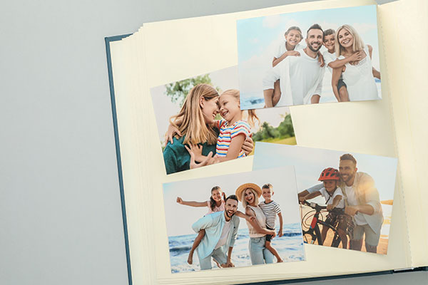 Album scrapbook aperto con fotografie e decorazioni applicate alle pagine