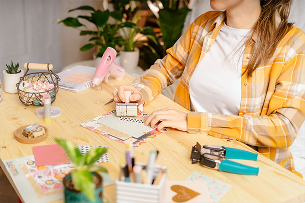 Ragazza che realizza un album scrapbook con foto, carte e decorazioni